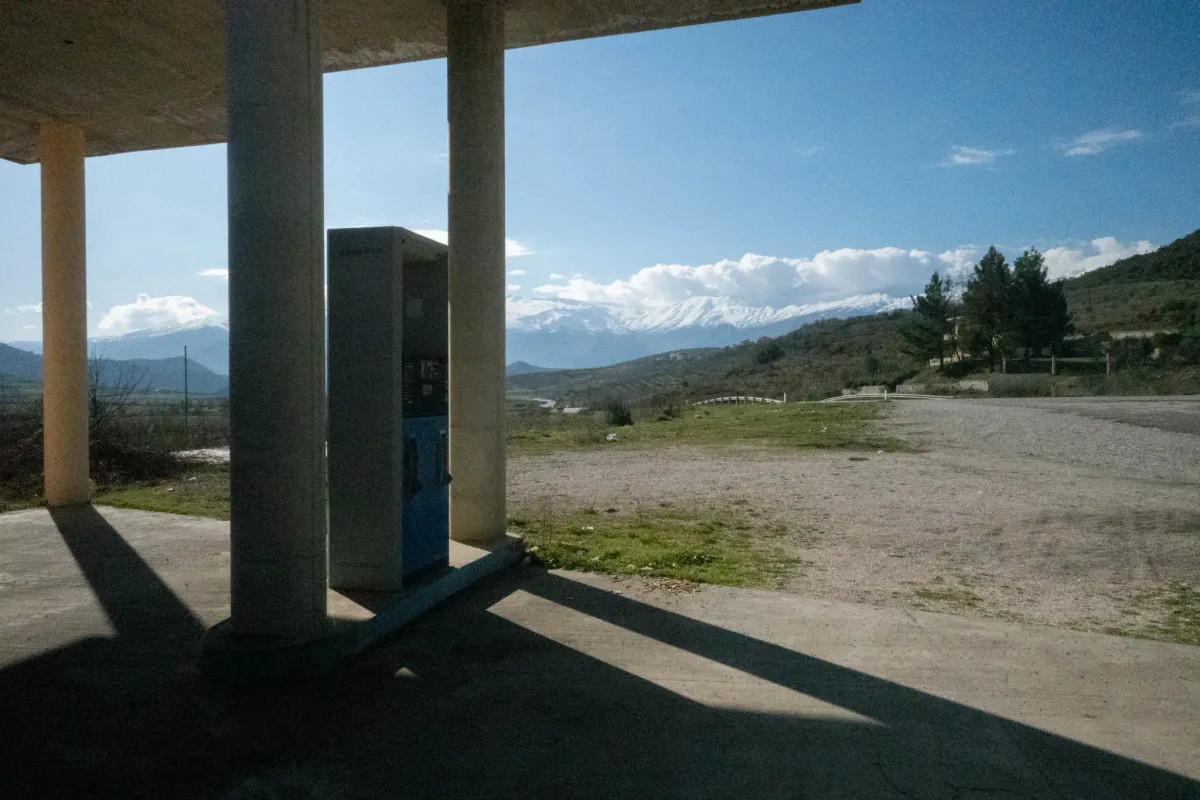 A quick bathroom, cigarette, and coffee break at a cafe next to an abandoned gas station.